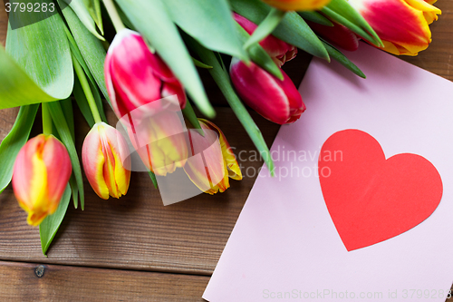 Image of close up of flowers and greeting card with heart