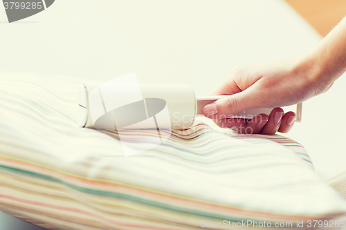 Image of close up of woman hand with sticky roller cleaning