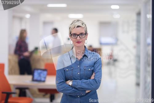 Image of portrait of young business woman at office with team in backgrou