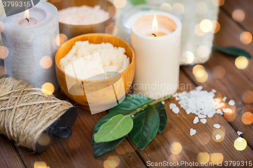 Image of close up of natural body scrub and candles on wood