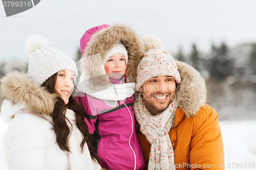 Image of happy family with child in winter clothes outdoors