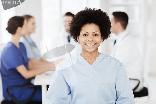 Image of happy doctor over group of medics at hospital