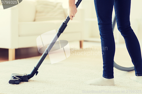 Image of close up of woman legs with vacuum cleaner at home