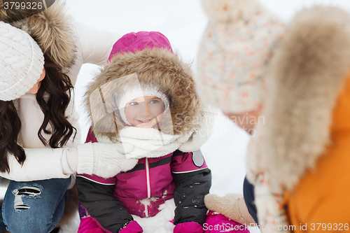 Image of happy family with child in winter clothes outdoors