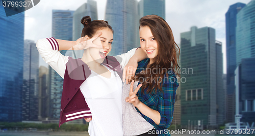 Image of happy pretty teenage girls showing peace hand sign