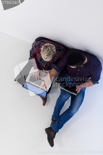 Image of top view of  couple working on laptop computer at startup office