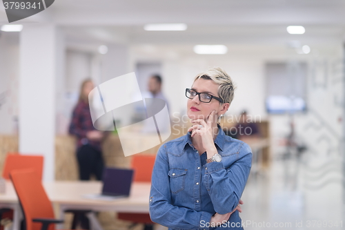 Image of portrait of young business woman at office with team in backgrou