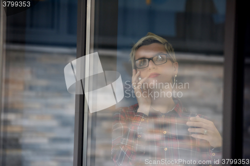 Image of business woman in meeting room  speaking by cell phone