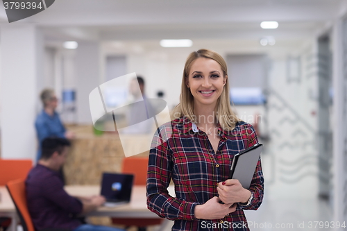 Image of portrait of young business woman at office with team in backgrou