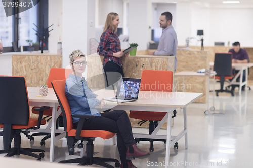 Image of portrait of young business woman at office with team in backgrou