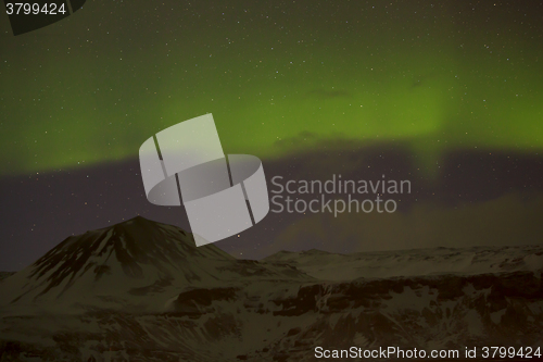 Image of Northern lights with snowy mountains in the foreground