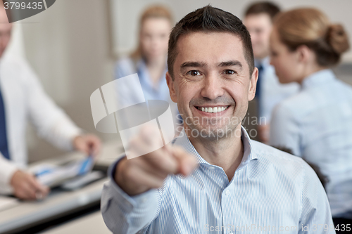 Image of group of smiling businesspeople meeting in office