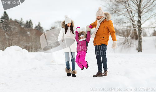 Image of happy family in winter clothes walking outdoors