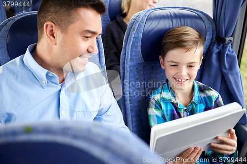 Image of happy family with tablet pc sitting in travel bus