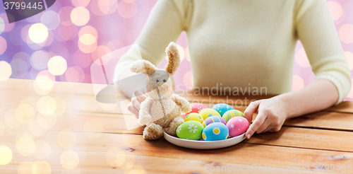 Image of close up of woman hands with easter eggs and bunny