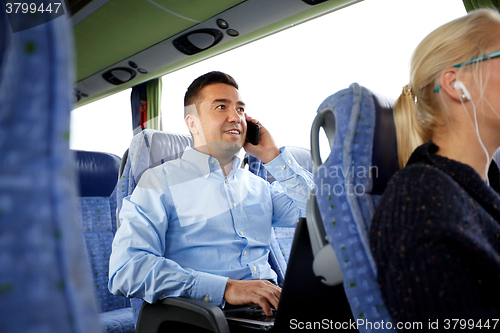 Image of happy man with smartphone and laptop in travel bus