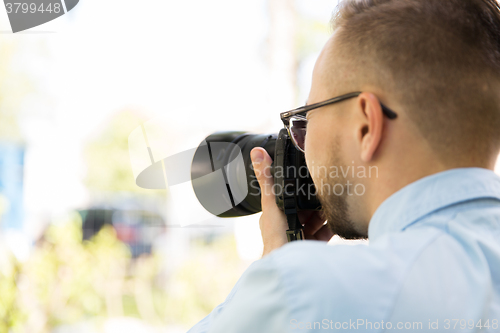 Image of close up of male photographer with digital camera