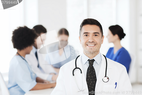 Image of happy doctor over group of medics at hospital