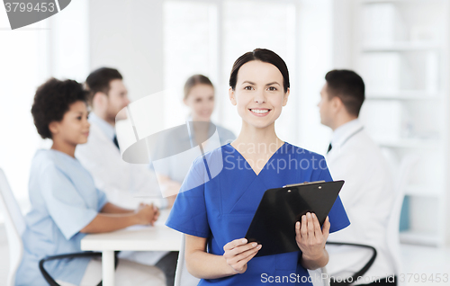 Image of happy doctor over group of medics at hospital