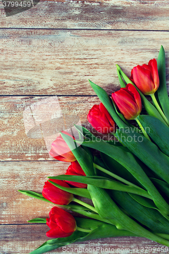 Image of close up of red tulips on wooden background