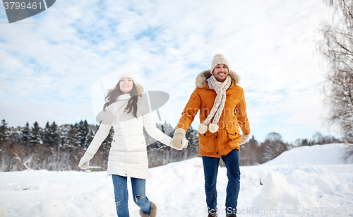 Image of happy couple running in winter snow