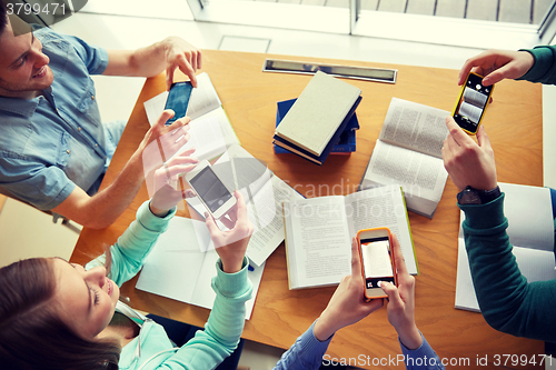 Image of students with smartphones making cheat sheets