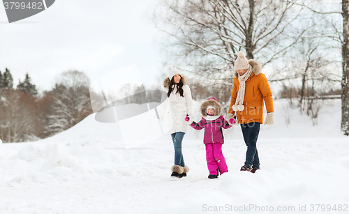 Image of happy family in winter clothes walking outdoors