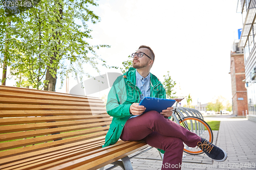 Image of happy young hipster man with tablet pc and bike