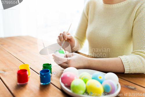 Image of close up of woman hands coloring easter eggs