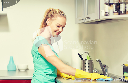 Image of happy woman cleaning table at home kitchen