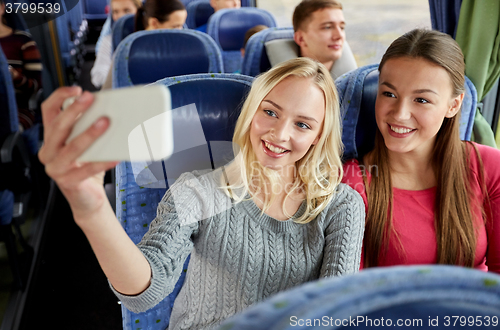 Image of women taking selfie by smartphone in travel bus
