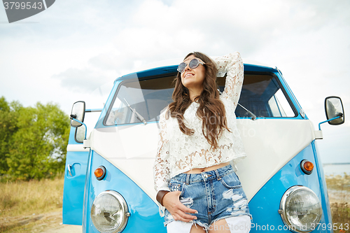 Image of smiling young hippie woman in minivan car