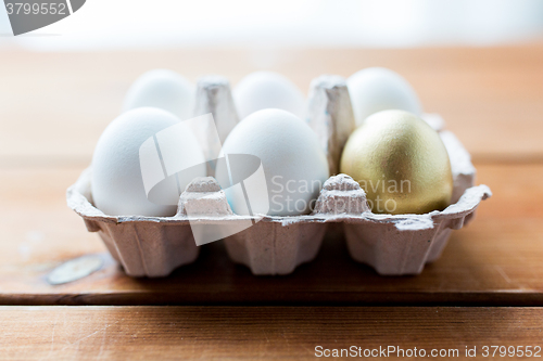 Image of close up of white and gold eggs in egg box