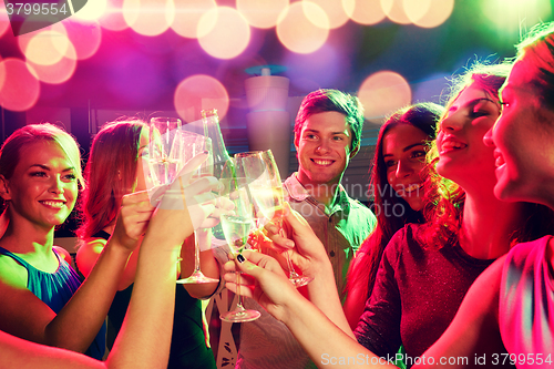 Image of smiling friends with wine glasses and beer in club