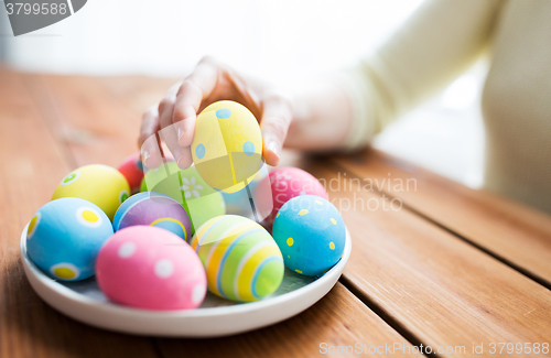 Image of close up of woman hands with colored easter eggs