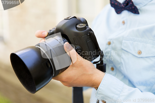 Image of close up of male photographer with digital camera