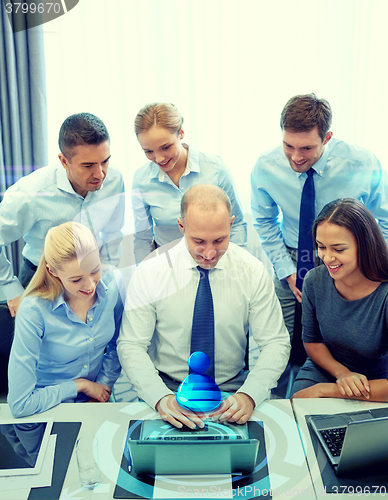 Image of smiling business people with laptop in office