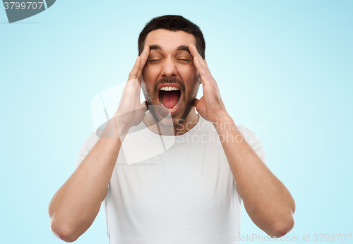 Image of crazy shouting man in t-shirt over blue background