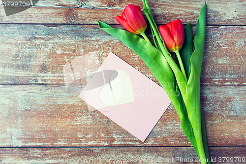 Image of close up of tulips and greeting card with heart