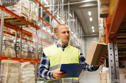 Image of man with clipboard in safety vest at warehouse