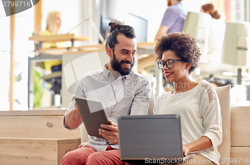 Image of creative team with laptop and tablet pc in office