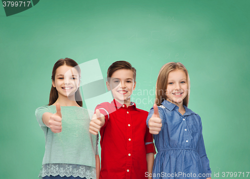 Image of happy children showing thumbs up over green board