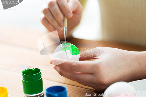 Image of close up of woman hands coloring easter eggs