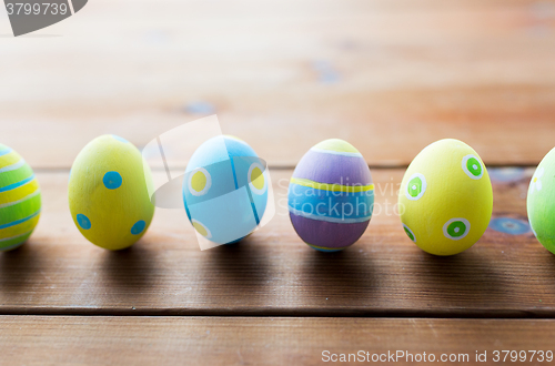 Image of close up of colored easter eggs on wooden surface