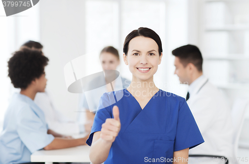 Image of happy doctor over group of medics at hospital