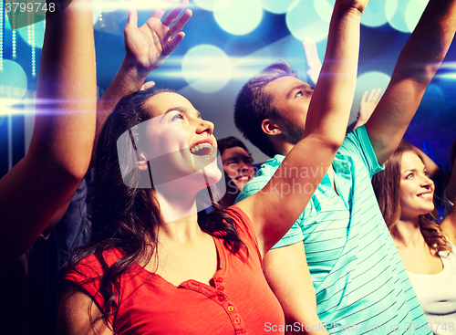 Image of smiling friends at concert in club