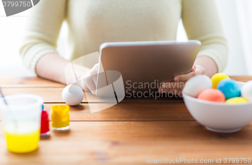 Image of close up of woman with tablet pc and easter eggs