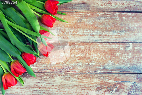 Image of close up of red tulips on wooden background