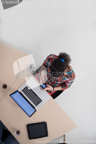Image of top view of young business woman working on laptop