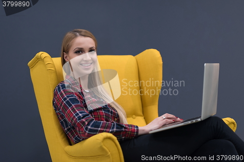 Image of startup business, woman  working on laptop and sitting on yellow